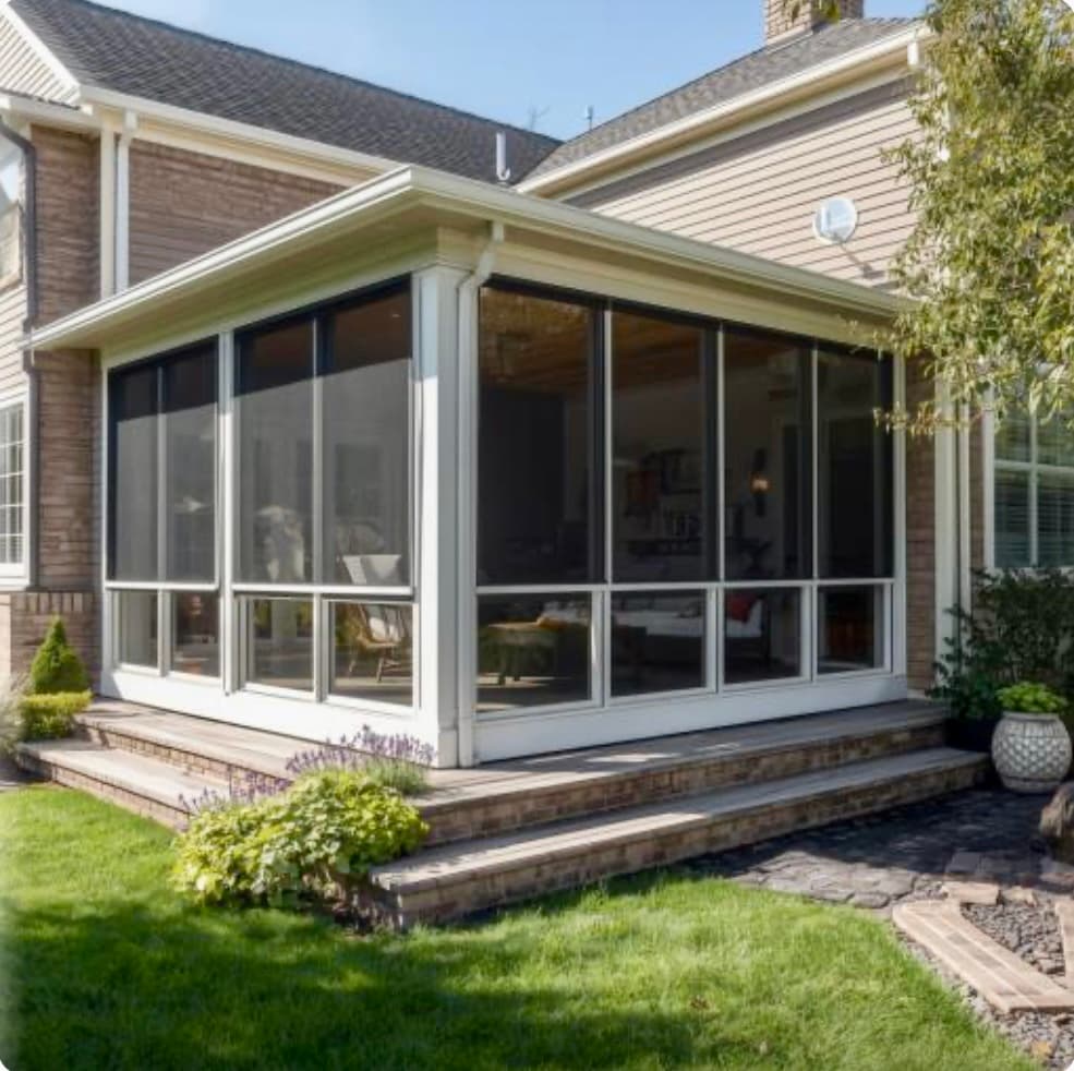 Glass-walled three-season sunroom with white trim by Vivid Outdoor Living